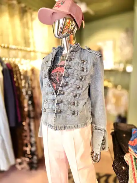Moderne denim jakke med dekorative knapper og pink cap.