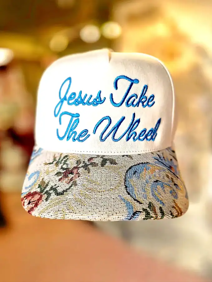 Cap med teksten 'Jesus Take The Wheel' i blå broderi.
