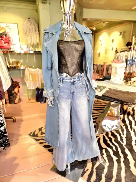 Stilfuld denimjakke med sort top på mannequin i butik.