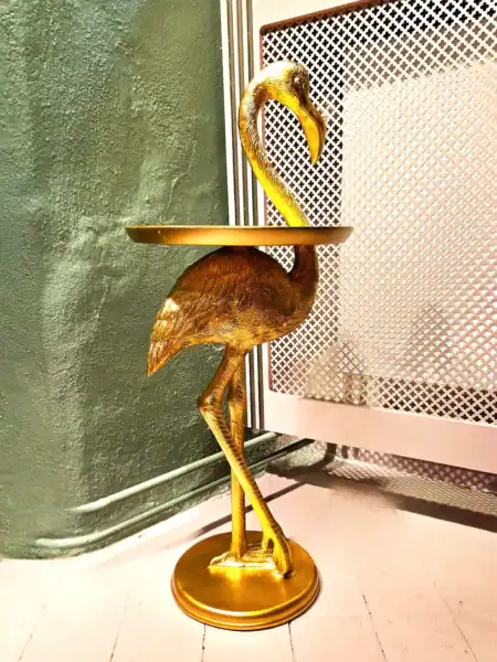 Elegant flamingo sidebord i guld med rund top og dekorativ base.