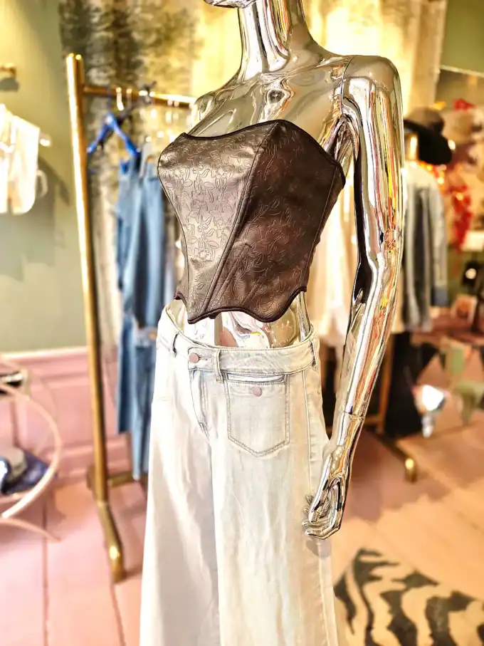 Modestil med lædertop og brede jeans, perfekt til forår og sommer.