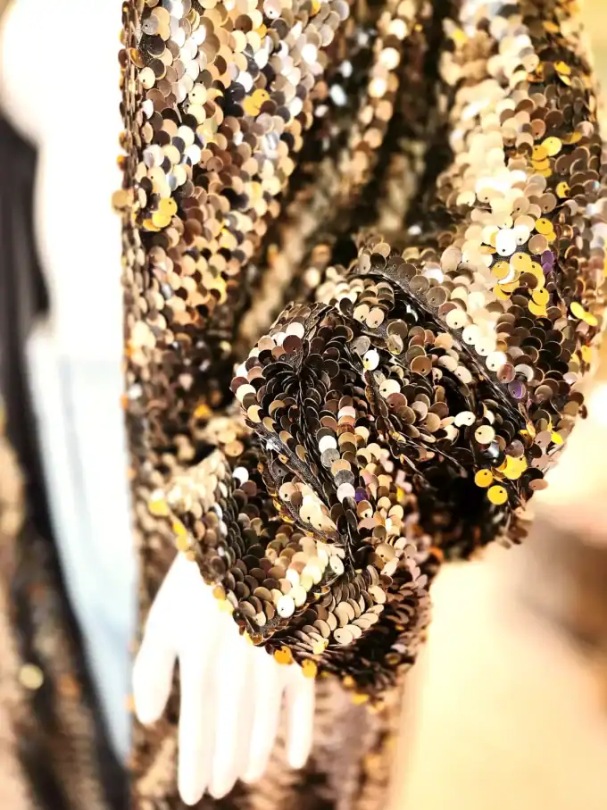 Detalje af pallietkimono med gyldent rattlesnake mønster, perfekt til festlige anledninger.