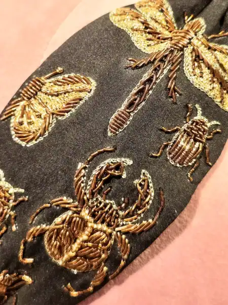Håndlavet cremefarvet hårbøjle med valmuer og insekter broderet i guld.