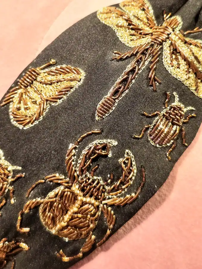 Håndlavet cremefarvet hårbøjle med valmuer og insekter broderet i guld.