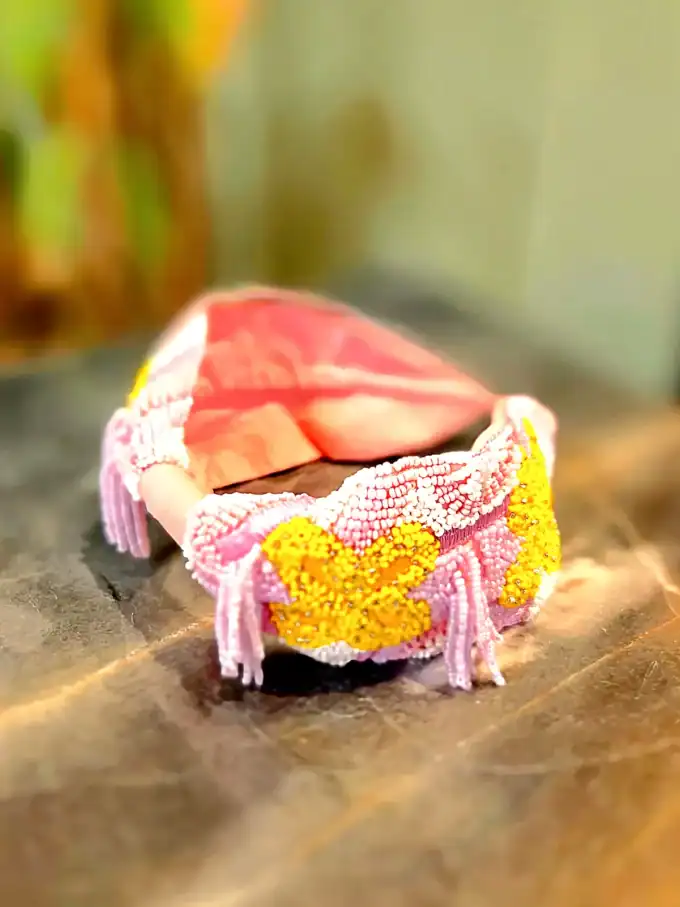 Håndlavet hårbøjle med guld- og tyrkise detaljer, perfekt til elegante looks.