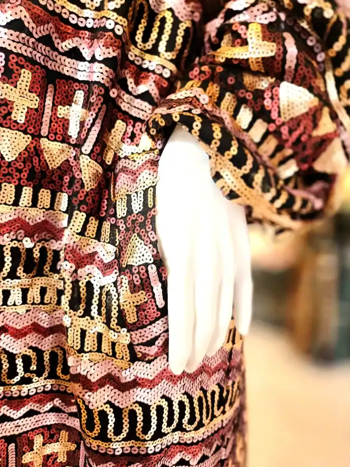 Detaljeret billede af palliet kimono med mosaikdesign og håndværksdetaljer.