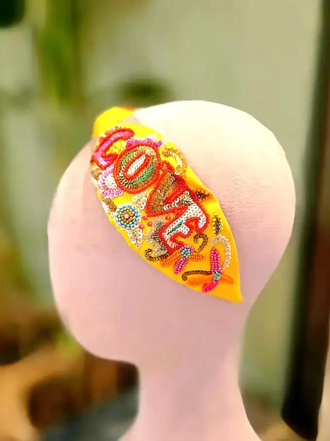 Farverig håndlavet hårbøjle med broderi og perler.
