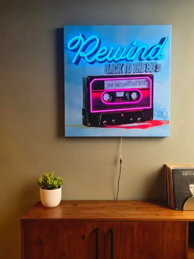 Vægspejl med neon-tekst 'Rewind' og kassettebånd, retro stil til vægdekoration.