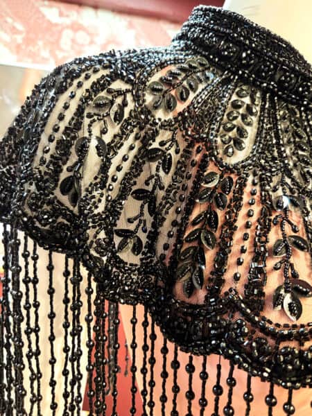 Sort perlekappe med elegante perler og detaljer.