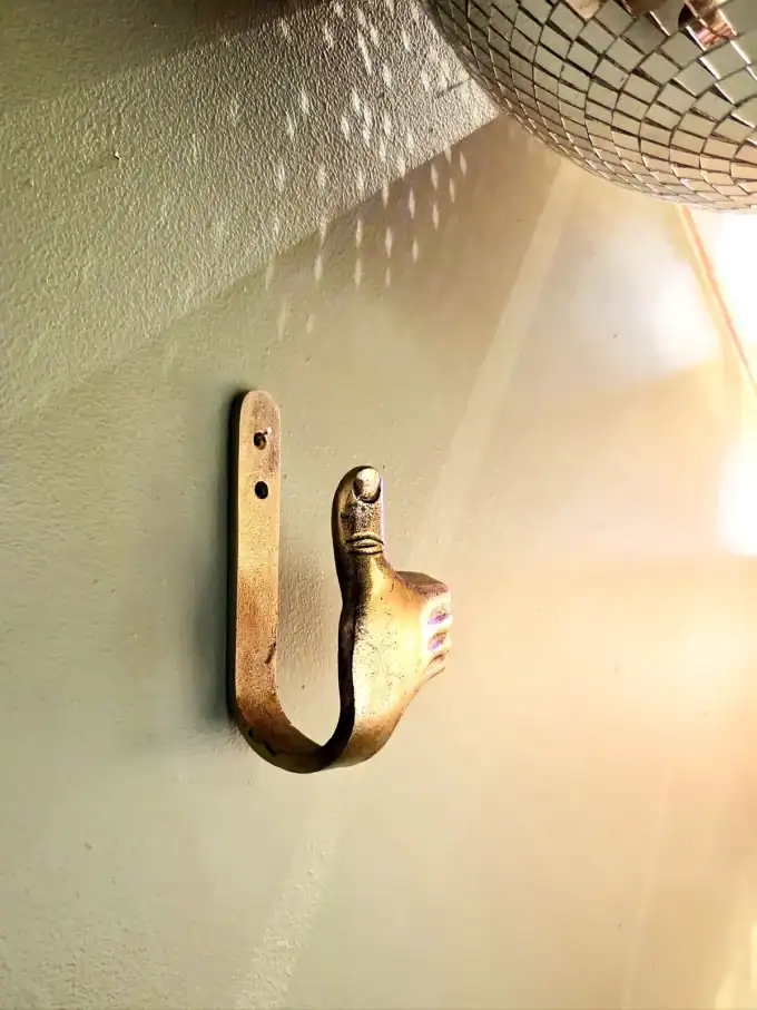 Elegant vægkrog med Thumbs Up design i sølvfinish.