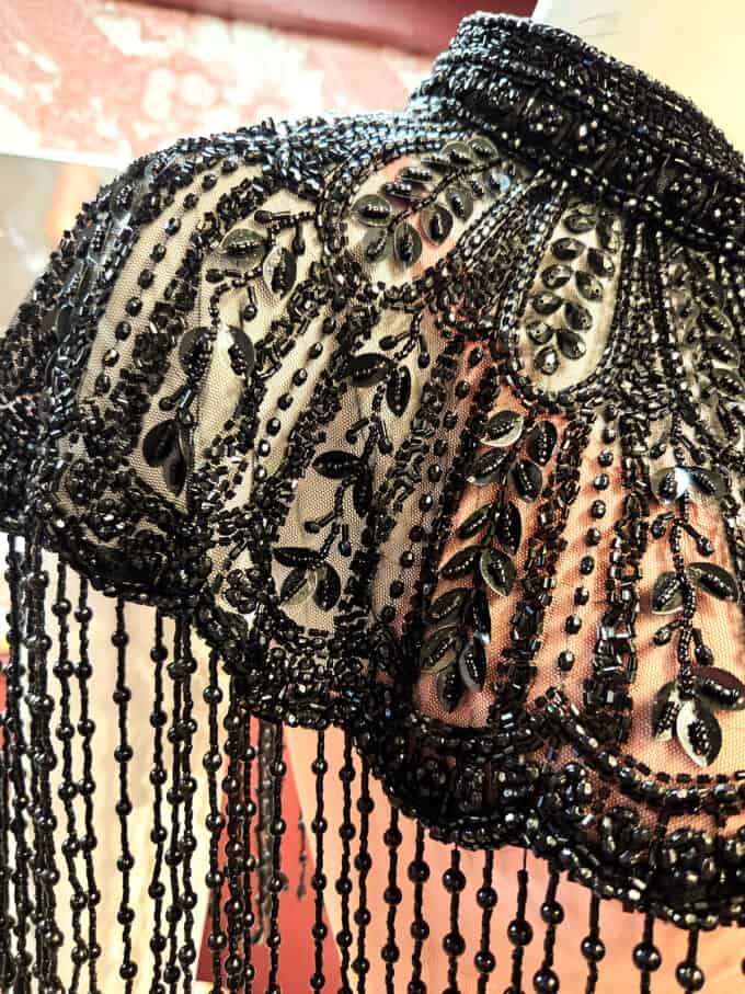 Sort perlekappe med elegante perler og detaljer.