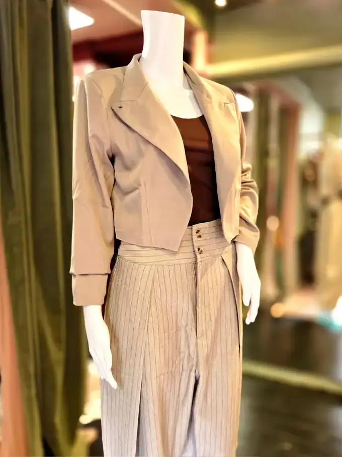 Stilfuldt outfit med beige bukser og jakke, perfekt til forår og efterår.