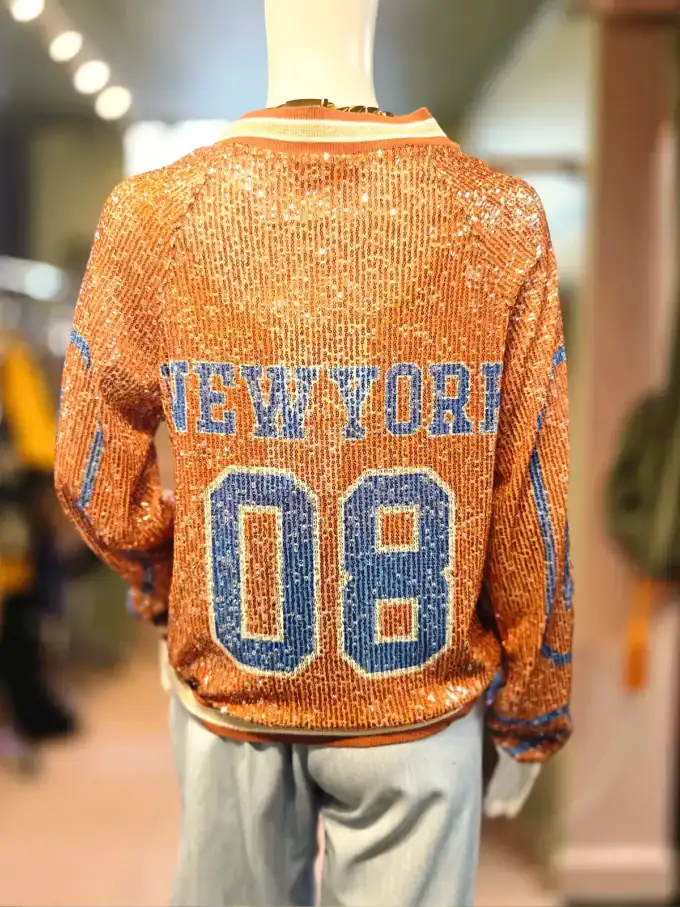 Palliet bomberjakke med glitrende pailletter og NY-tryk i blå og orange farver.