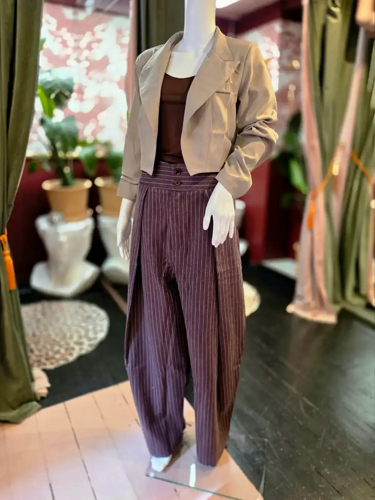 Moderne kvindeklæder med bukser, blazer og top i butiksmiljø.