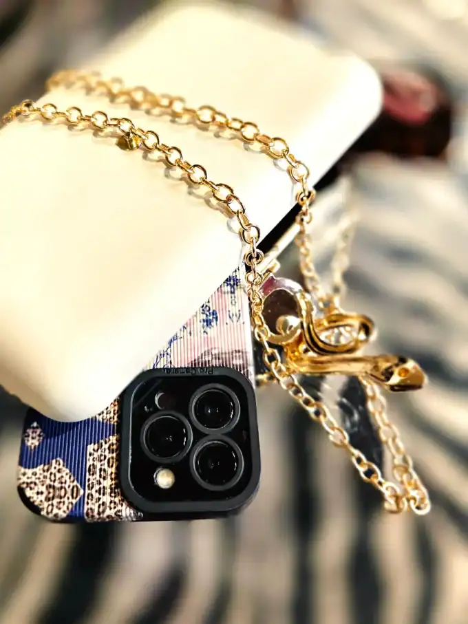 Elegant slange clutch med guldbelagt kæde og tilbehør.