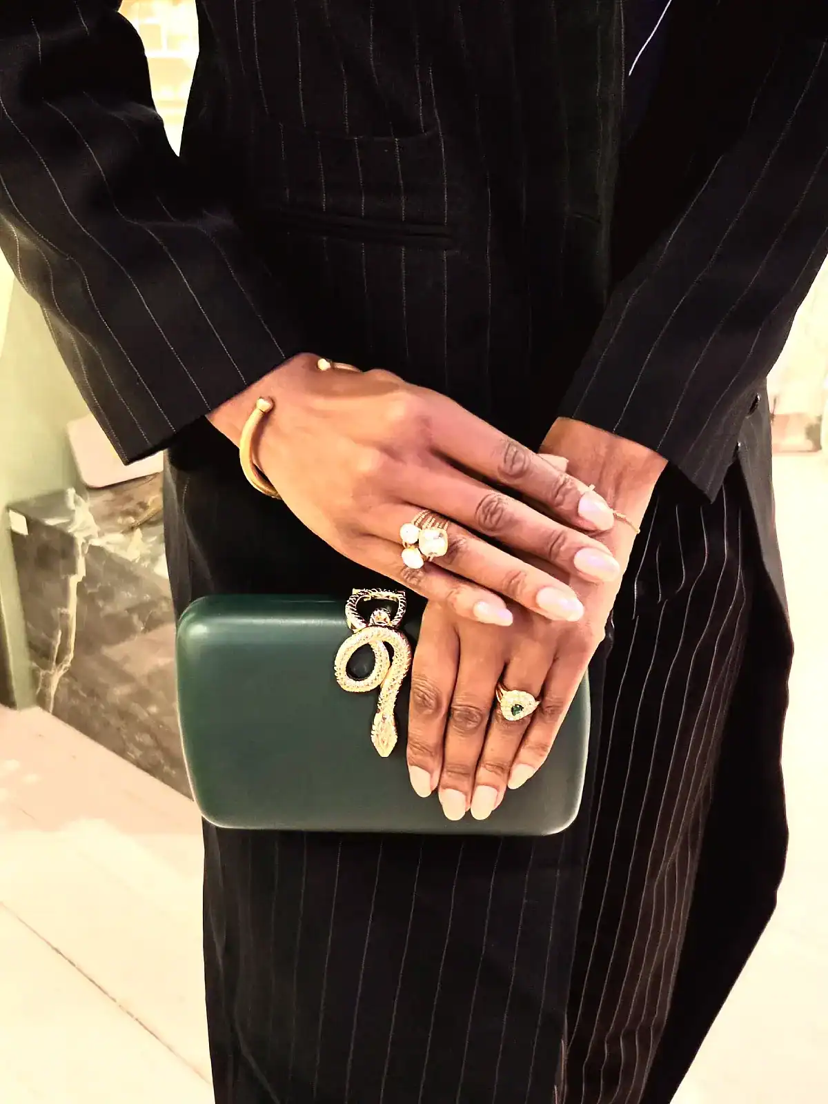 Elegant grøn slange clutch med gulddetaljer og håndplukkede accessories.