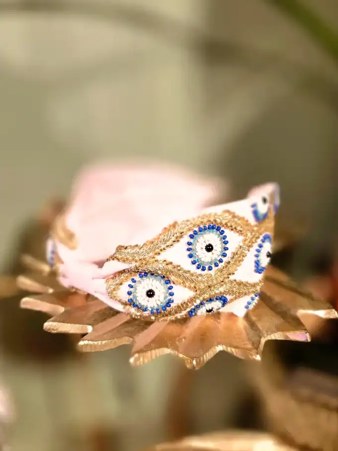 Sort hårbøjle med guld- og perleblomster, perfekt til elegante looks.