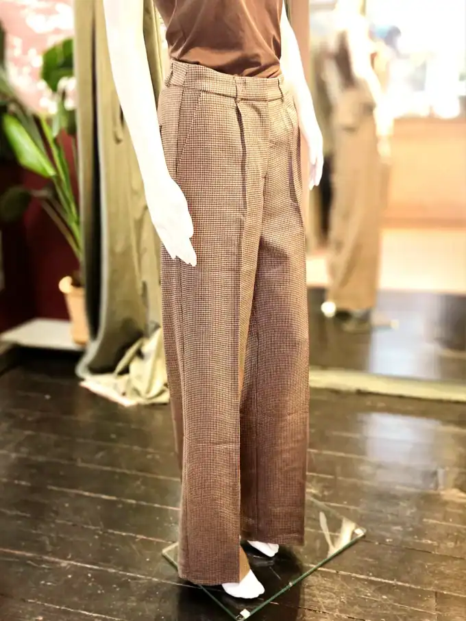 Ternede habitbukser med brede ben på mannequin i butik.