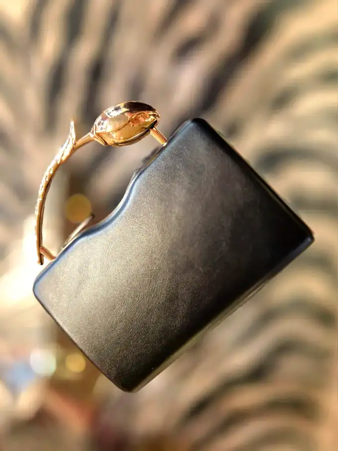 Sort Rose Clutch med guldbeslag, elegant tilbehør til festlige anledninger.