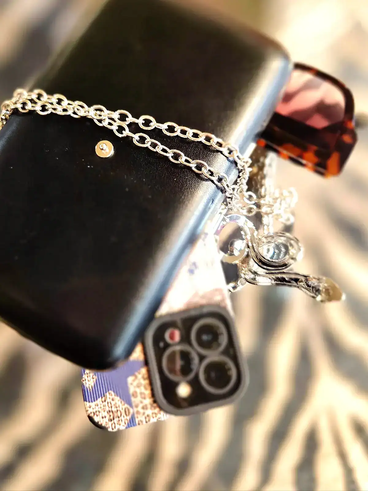 Elegant beige clutch med tilbehør og smartphone.