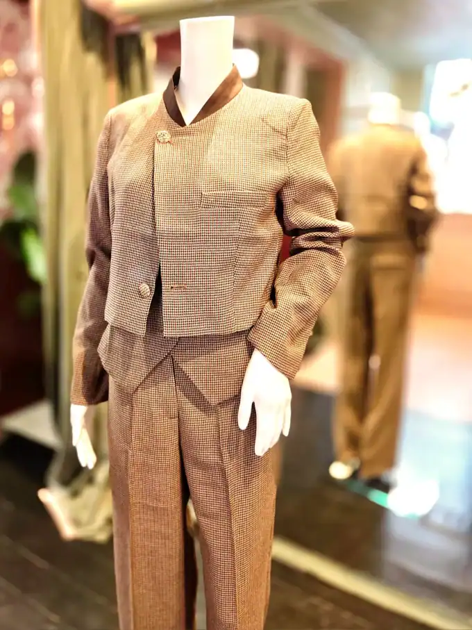 Ternet habitvest og bukser på mannequin i butik.