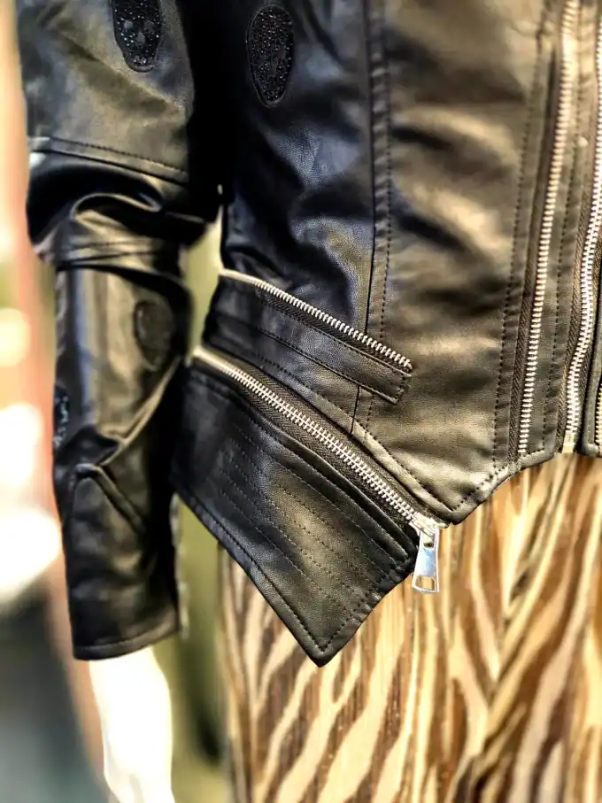 Sort læderbikerjakke med zippers og detaljer.