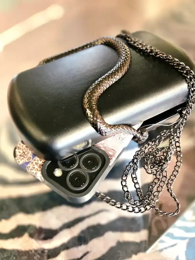 Sort slange clutch med kæde til stilfuldt look.