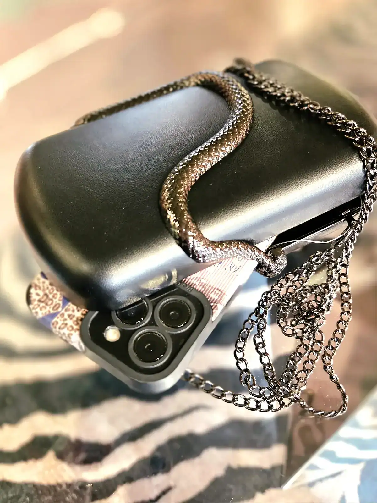 Sort slange clutch med kæde til stilfuldt look.