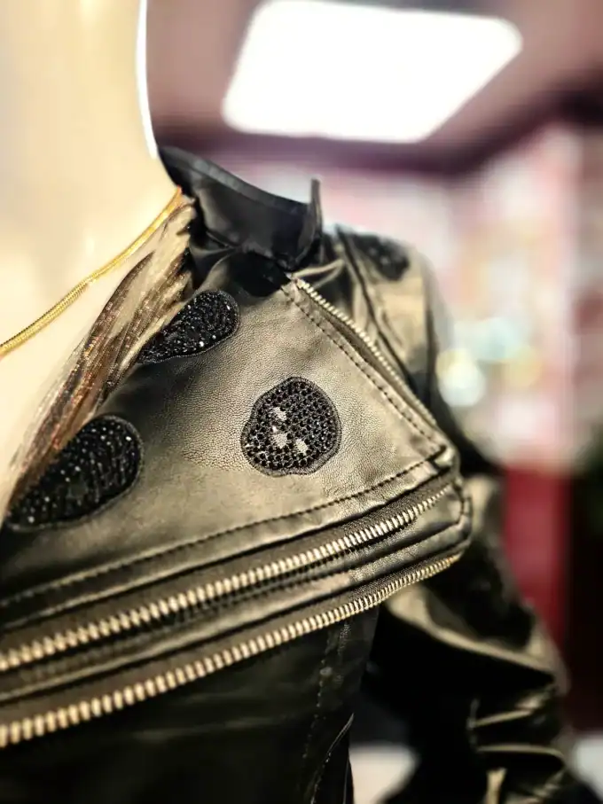 Sort bikerjakke med skull-prints og glitrende detaljer.