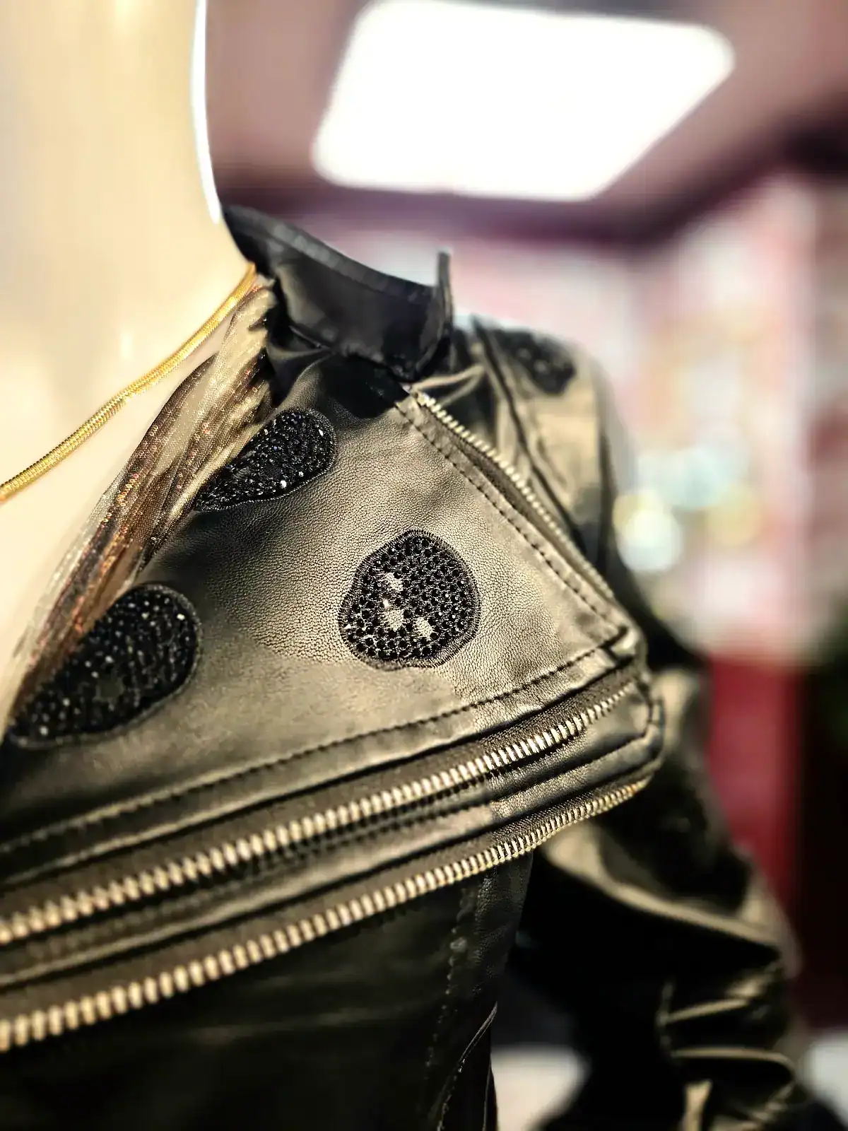 Sort bikerjakke med skull-prints og glitrende detaljer.