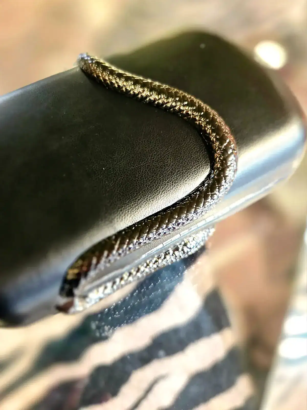 Sort slange clutch med glitrende detaljer, elegant og stilfuld accessory.