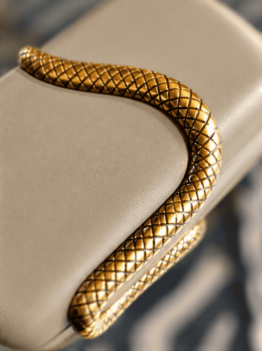 Elegant slange clutch i khaki med gulddetaljer, perfekt til fest og aftenbrug.